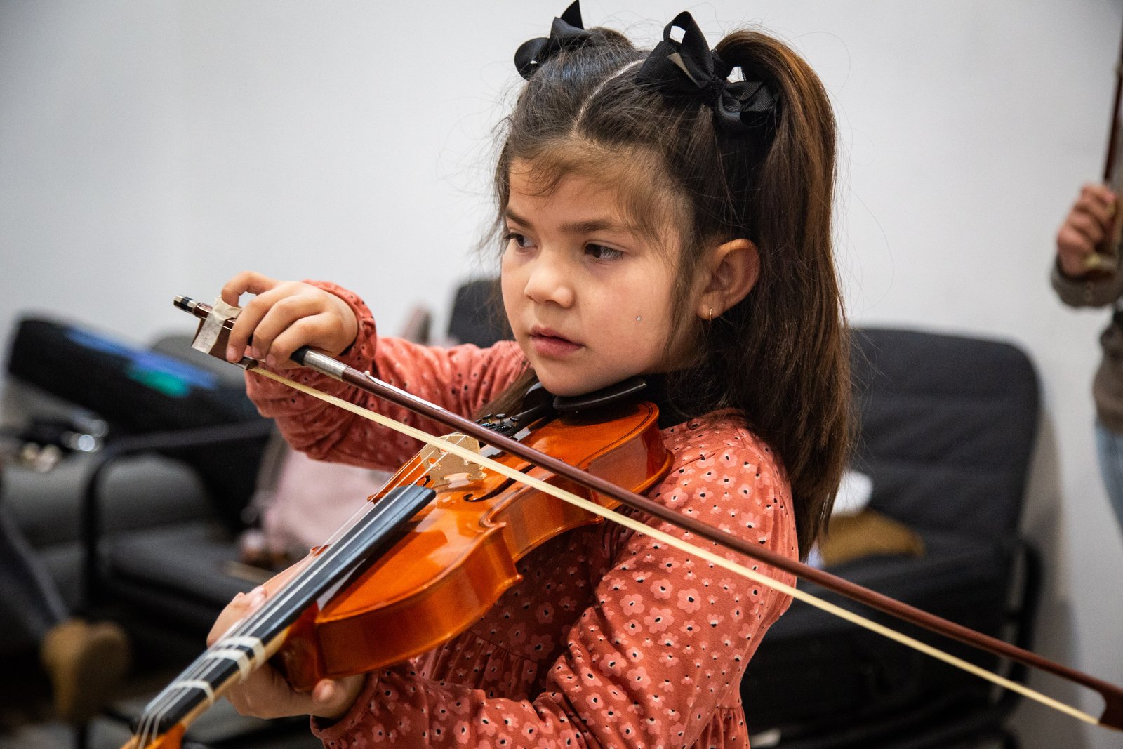 Niña afinando de cerca su violín en el Taller de Violín Rukamalon