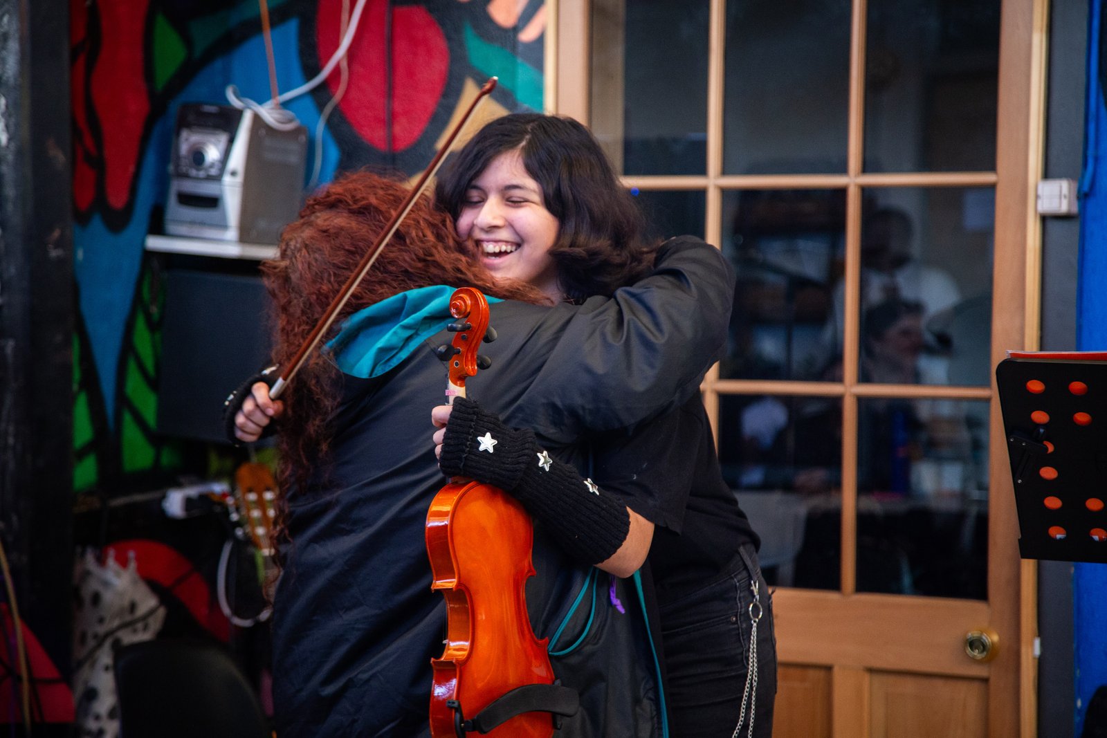 Tallerista y alumna celebrando con el violín, Rukamalon