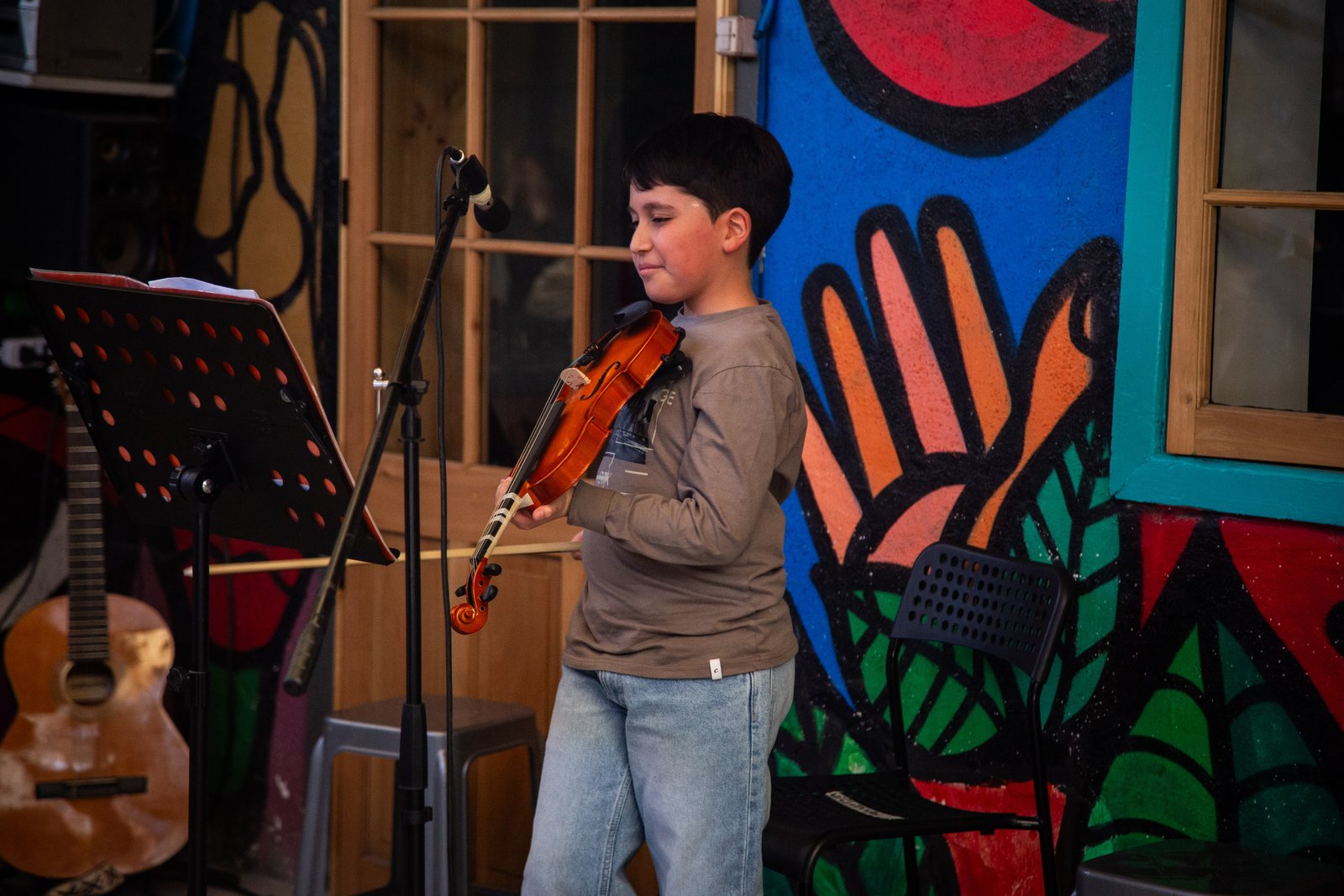 Niño tocando violín en presentación, Rukamalon